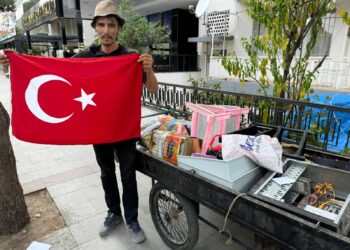 Hurdacı çöpte bulduğu bayrağı yıkayıp hurda arabasına astı