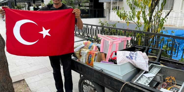 Hurdacı çöpte bulduğu bayrağı yıkayıp hurda arabasına astı