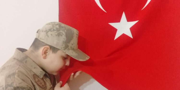 Yere düşen bayrağı öperek alan öğrenciye anlamlı ödül